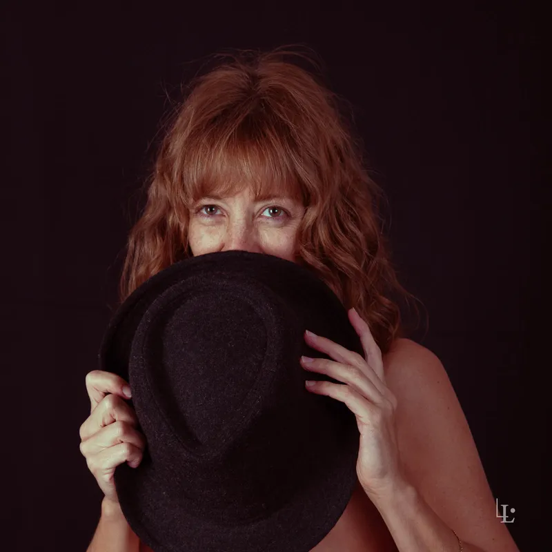 Femme souriante avec un chapeau noir